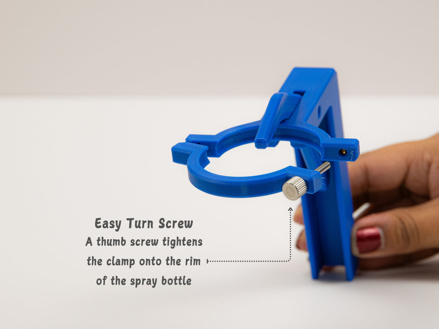 Close-up of the clamping mechanism, showing the thumb screw design that secures the spray assistant onto the neck of the bottle for a snug fit.
