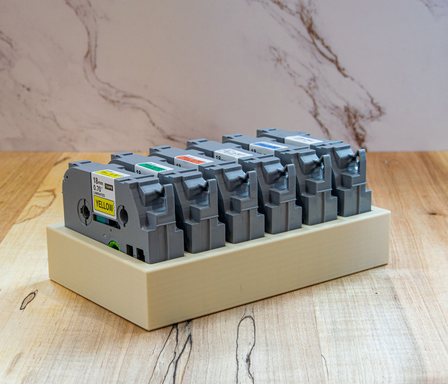 18mm Brother label tapes organized side-by-side in a beige storage tray, showing clear color-coded accessibility for efficient labeling.