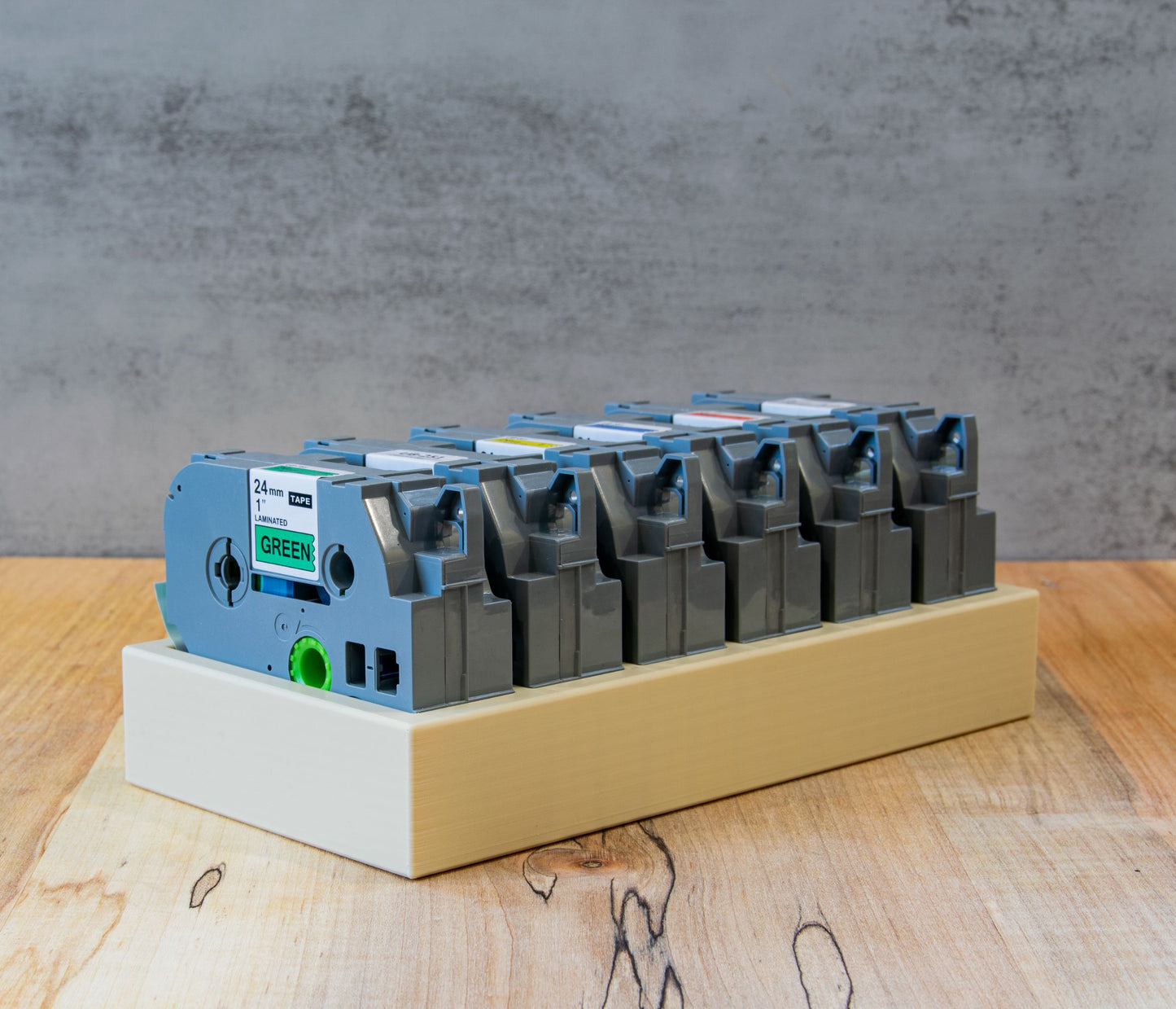 Close-up view of Brother-compatible 24mm label tapes stored vertically in an organizer tray, showcasing clean and efficient tape arrangement.