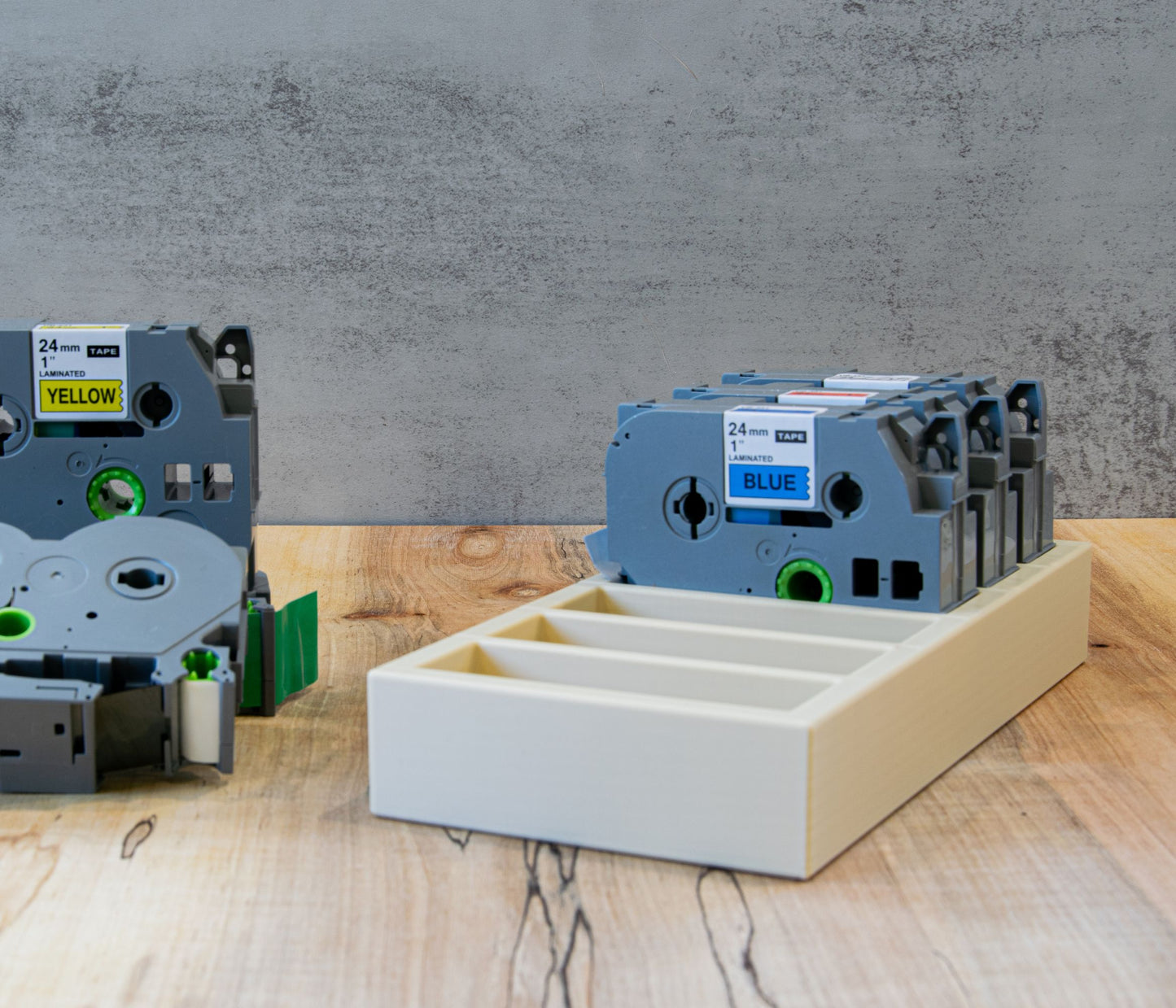 Comparison of loose 24mm Brother label tapes versus those stored in a beige organizer, emphasizing neatness and accessibility of color-coded tapes.