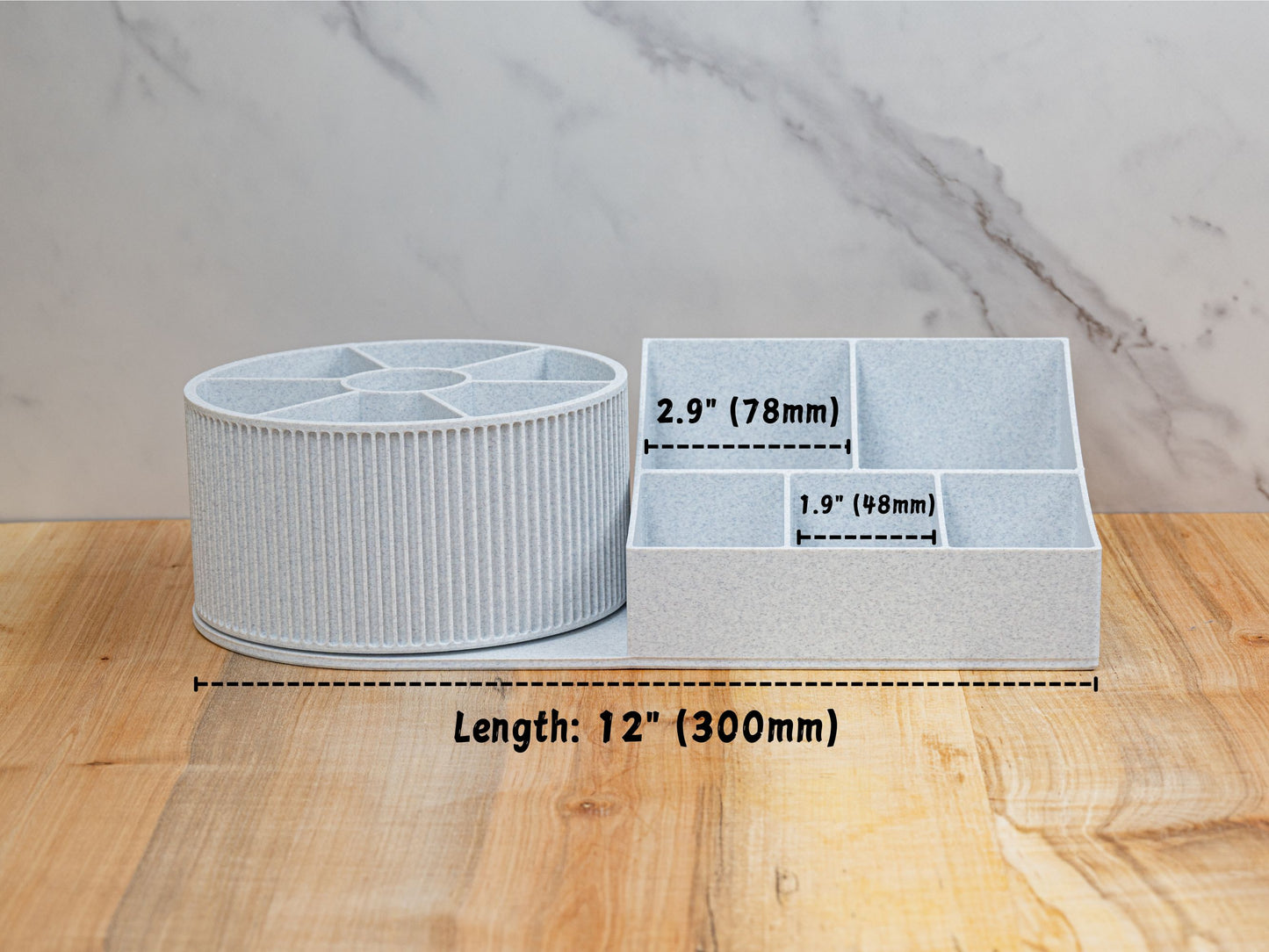 Front measurement graphic of the rotating beauty organizer on a wood surface: overall length labeled 12 in (300 mm). Base compartments annotated with interior widths of 2.9 in (78 mm) for the larger sections and 1.9 in (48 mm) for the smaller sections.