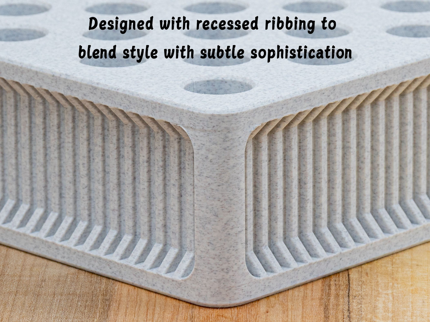 Close-up macro detail of the square ScentSplit perfume organizer’s recessed ribbing along the side. The rounded edges of the square frame add refinement. On-image caption reads: “Designed with recessed ribbing to blend style with subtle sophistication.”