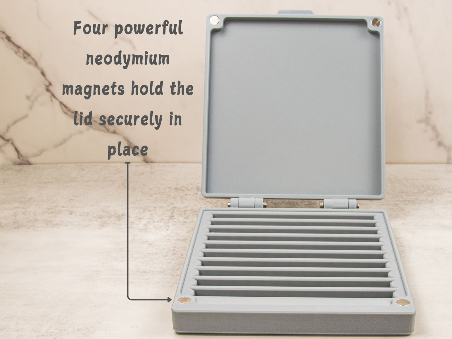 Open sharpening stone case showing four embedded neodymium magnets in the corners of the lid for secure closure.