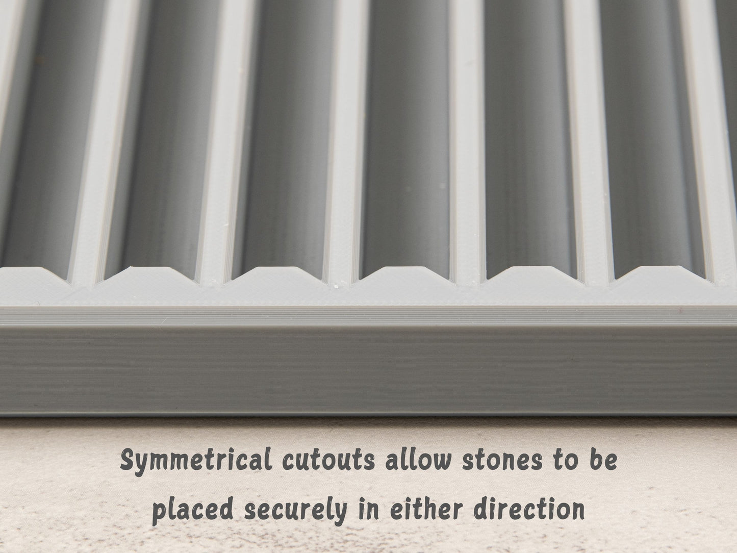 Close-up image of symmetrical slot cutouts in sharpening stone tray, designed to securely hold stones in either orientation.