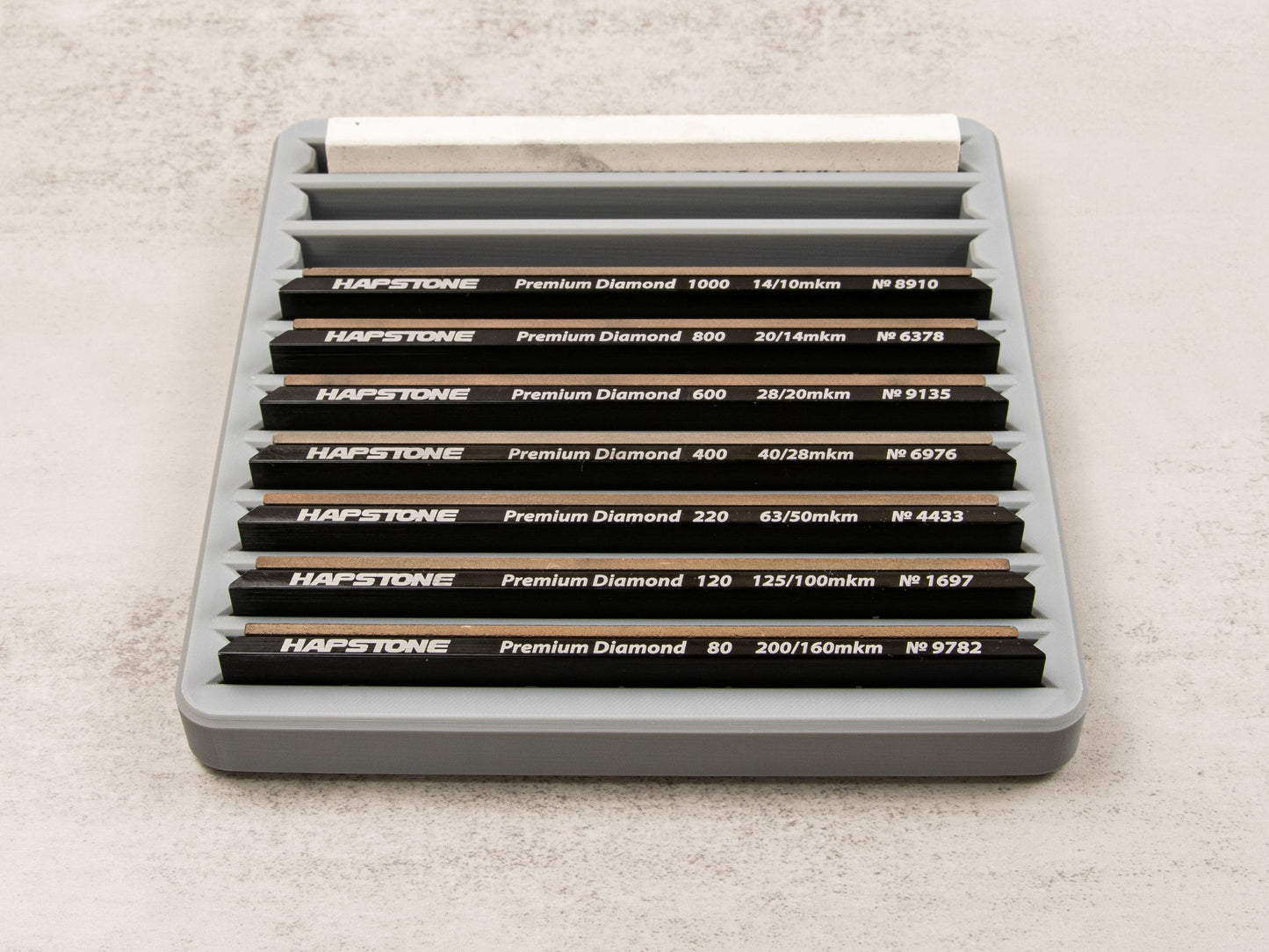 Sharpening stone tray filled with 10 premium diamond stones organized by grit level, showcasing maximum capacity.