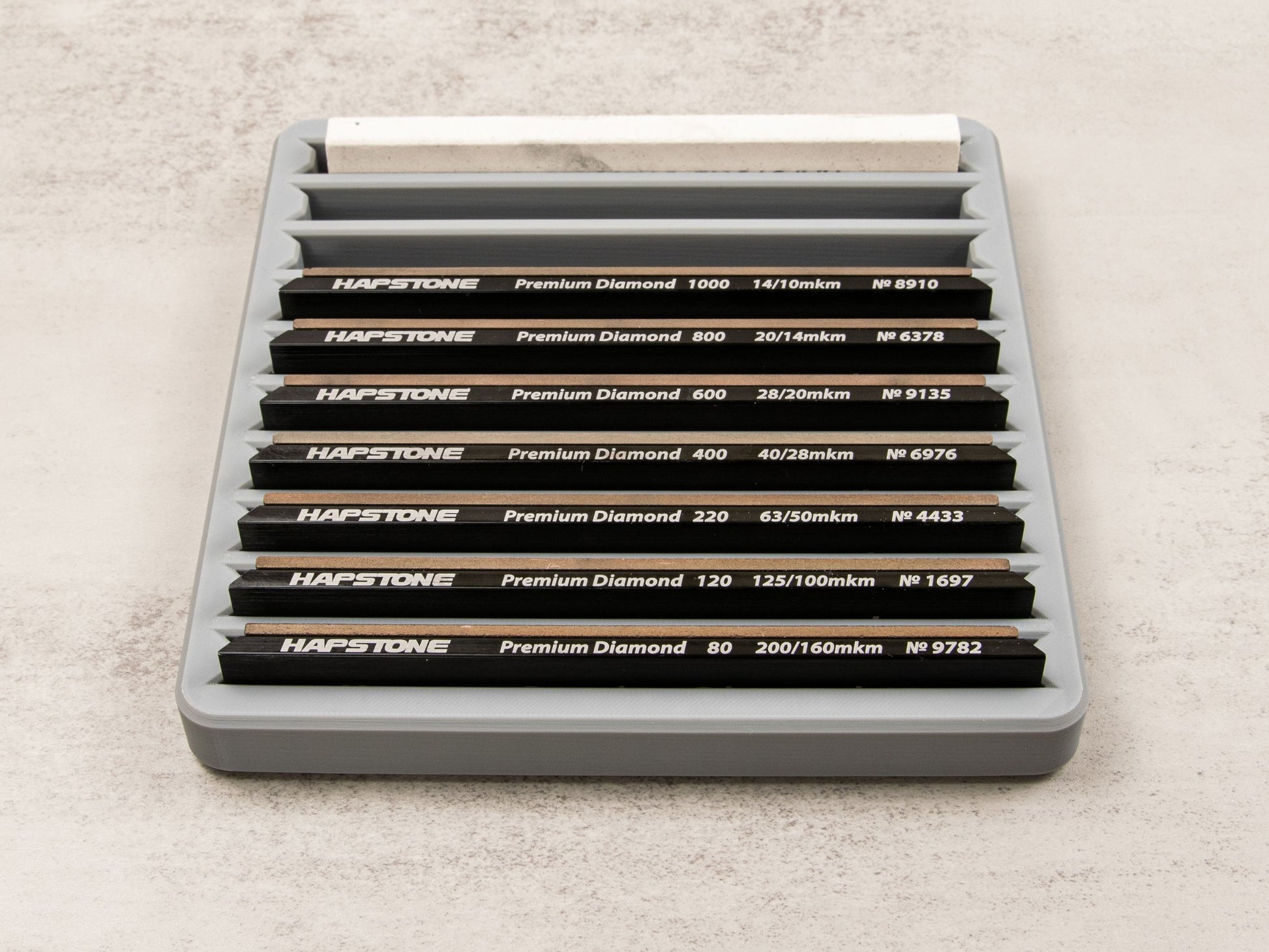 Sharpening stone tray filled with 10 premium diamond stones organized by grit level, showcasing maximum capacity.

